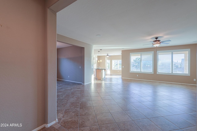 unfurnished room with ceiling fan and light tile patterned floors