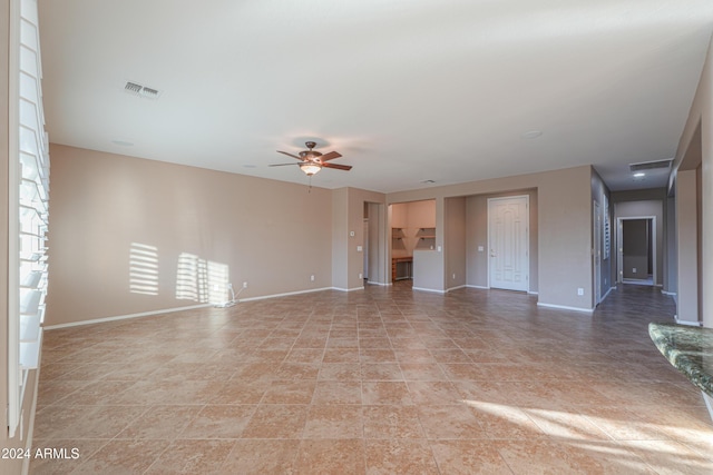 unfurnished living room featuring light tile patterned floors and ceiling fan