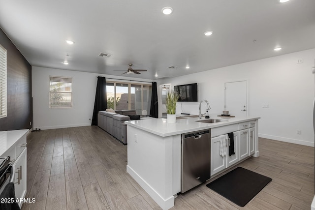 kitchen featuring sink, a center island with sink, light wood-type flooring, dishwasher, and white cabinets