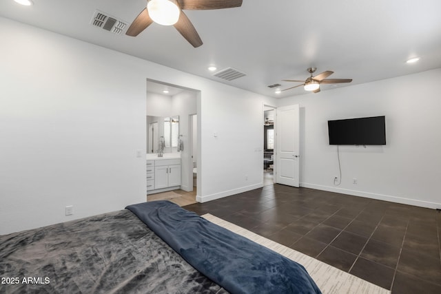 bedroom featuring dark tile patterned floors, ceiling fan, and ensuite bath