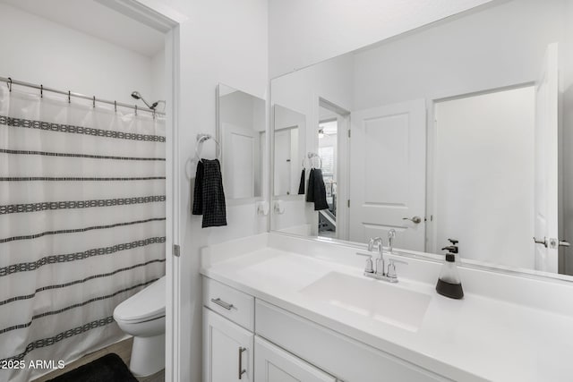 bathroom with a shower with curtain, vanity, and toilet