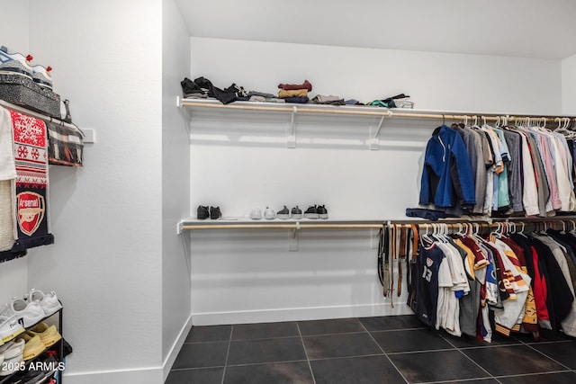 walk in closet with dark tile patterned flooring