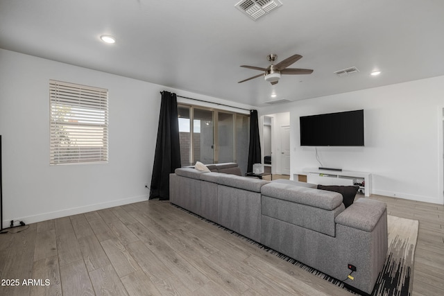 living room with ceiling fan, light hardwood / wood-style floors, and a healthy amount of sunlight