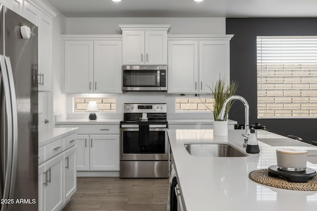 kitchen featuring white cabinetry, sink, hardwood / wood-style flooring, and stainless steel appliances