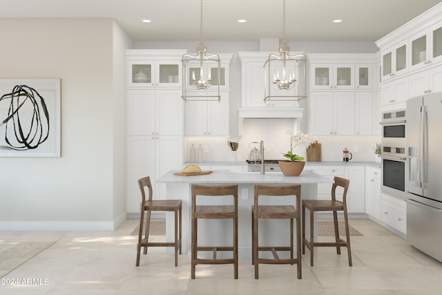 kitchen with a center island with sink, white cabinets, and stainless steel appliances