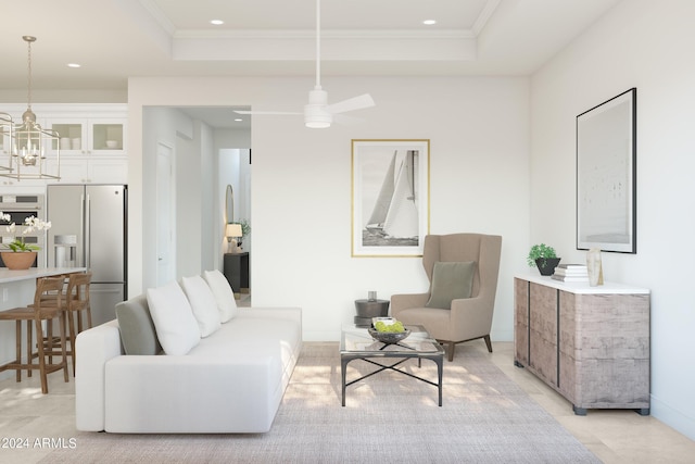 living room with ceiling fan with notable chandelier, a tray ceiling, and crown molding