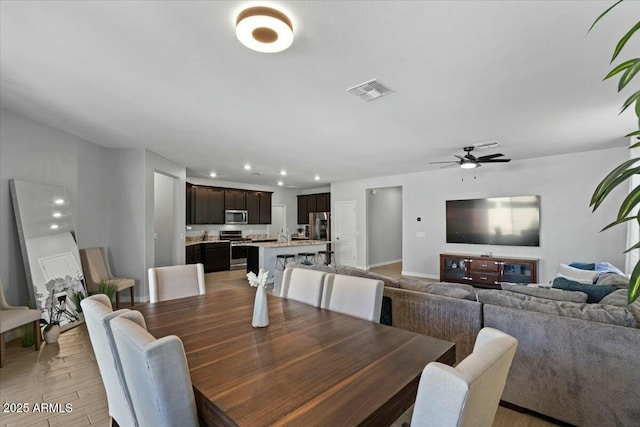 dining space with light hardwood / wood-style floors and ceiling fan