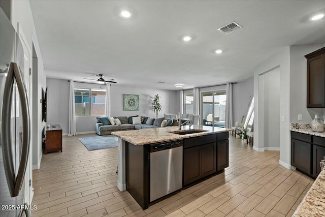 kitchen with stainless steel appliances, ceiling fan, plenty of natural light, and dark brown cabinets