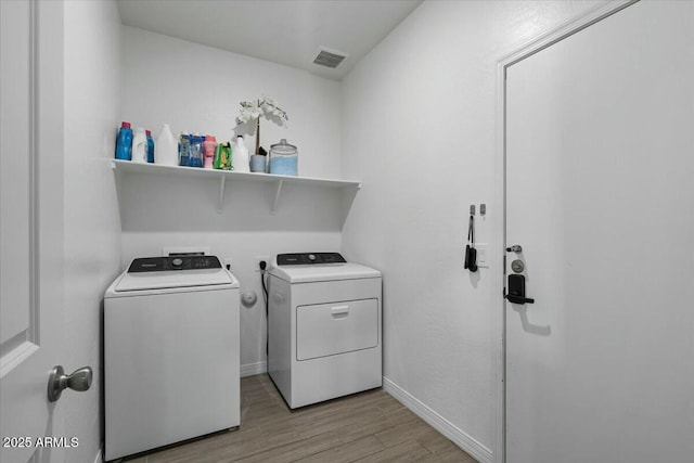 laundry area featuring light hardwood / wood-style floors and washer and clothes dryer