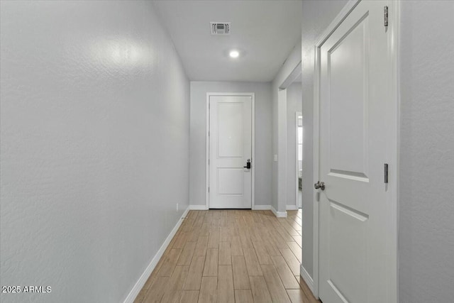 hallway with light hardwood / wood-style flooring