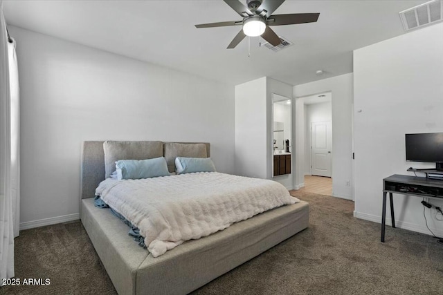 carpeted bedroom with ensuite bathroom and ceiling fan