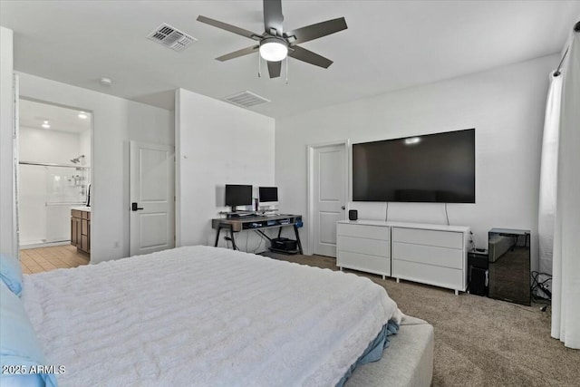 carpeted bedroom featuring ceiling fan and ensuite bathroom