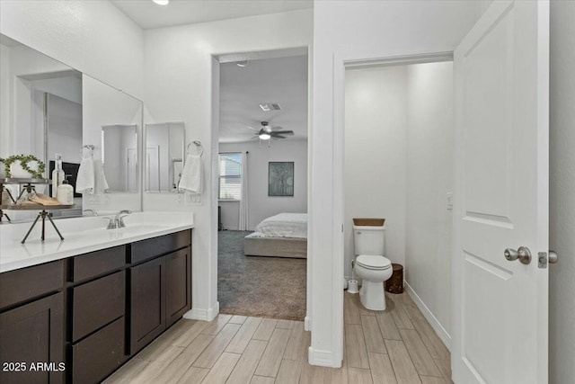 bathroom featuring toilet, ceiling fan, and vanity