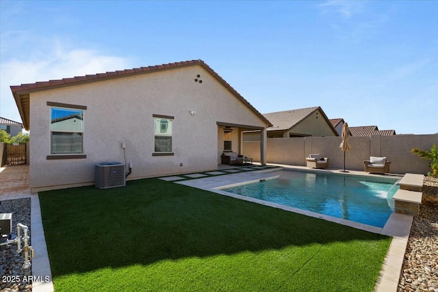 view of swimming pool with a lawn, pool water feature, cooling unit, and a patio