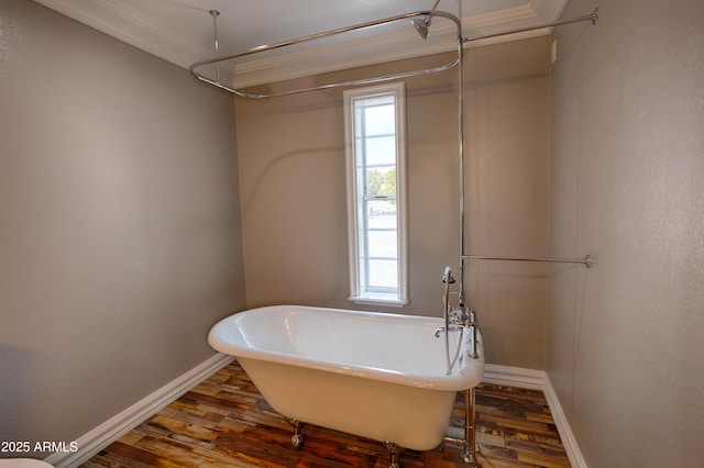 bathroom with a tub to relax in, ornamental molding, and hardwood / wood-style floors