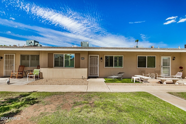 rear view of property featuring a yard and a patio area