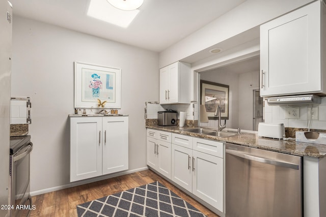 kitchen featuring sink, white cabinetry, stainless steel appliances, dark stone countertops, and dark hardwood / wood-style flooring