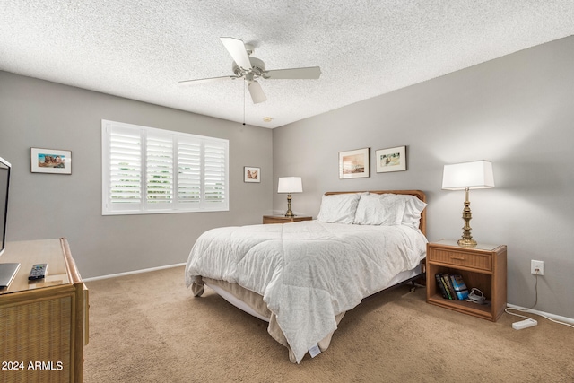 bedroom featuring a textured ceiling, ceiling fan, and light colored carpet