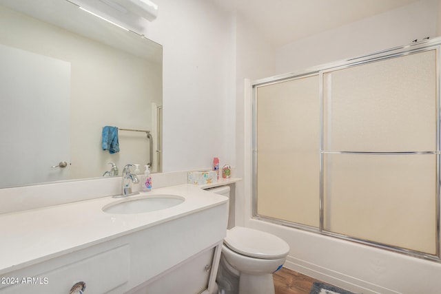 full bathroom with enclosed tub / shower combo, wood-type flooring, vanity, and toilet