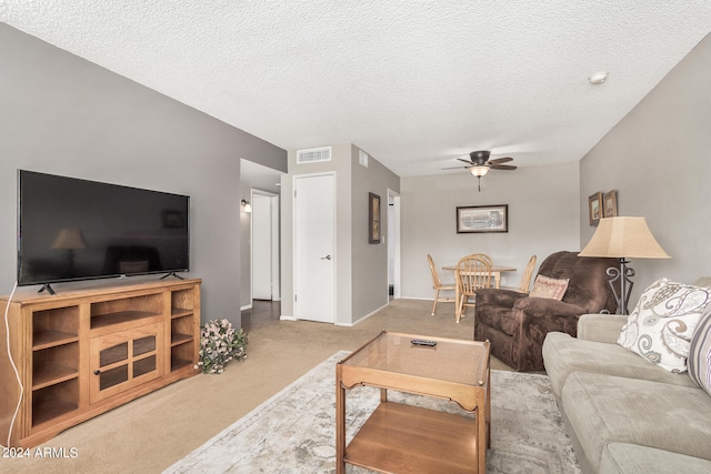 carpeted living room featuring a textured ceiling and ceiling fan