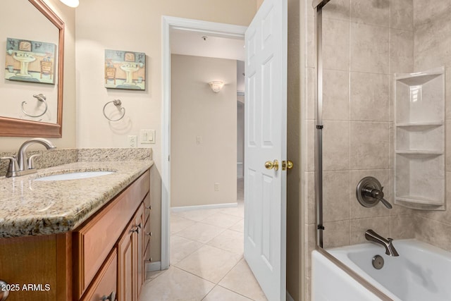 bathroom featuring tile patterned flooring, tiled shower / bath, and vanity