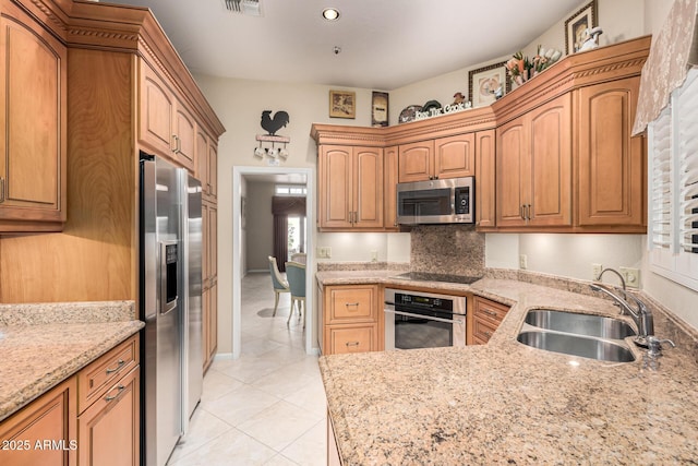 kitchen with light stone counters, appliances with stainless steel finishes, light tile patterned flooring, and sink