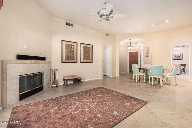 interior space with ceiling fan and a tile fireplace