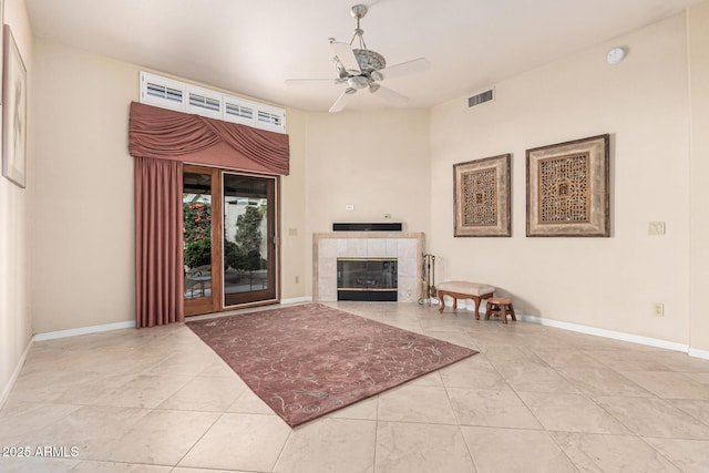 tiled living room with a fireplace and ceiling fan