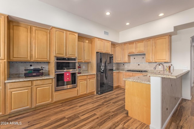 kitchen with light stone countertops, decorative backsplash, stainless steel appliances, and dark hardwood / wood-style floors