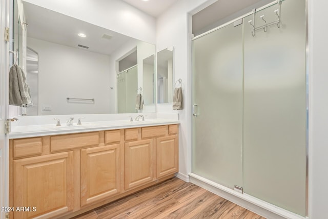 bathroom with vanity, a shower with shower door, and hardwood / wood-style flooring