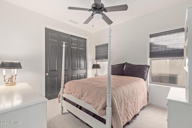 carpeted bedroom with ceiling fan and a closet