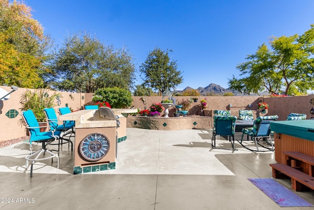 view of patio with area for grilling and a mountain view