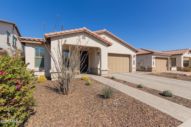 mediterranean / spanish-style home with concrete driveway, an attached garage, a tile roof, and stucco siding