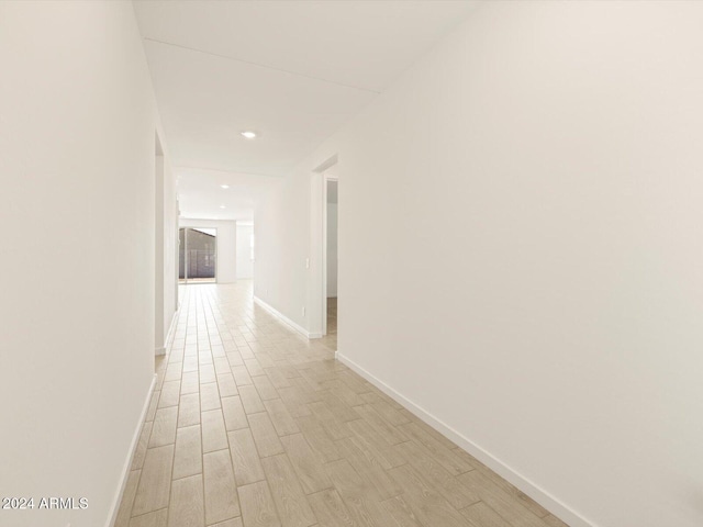 corridor with light hardwood / wood-style floors