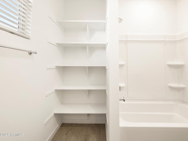 bathroom with shower / bathtub combination and hardwood / wood-style flooring