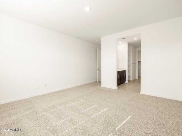 unfurnished room featuring light carpet