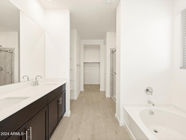 bathroom with independent shower and bath, vanity, and wood-type flooring