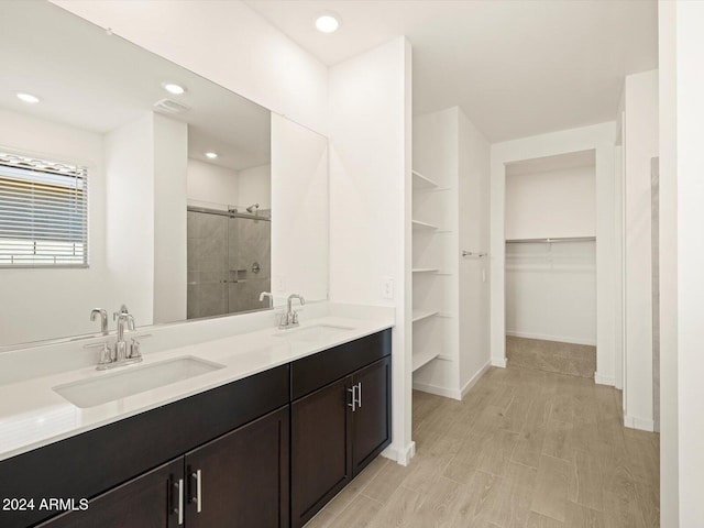 bathroom with hardwood / wood-style flooring, vanity, and walk in shower