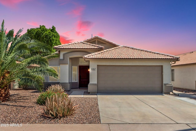 1057 W Laurel Ave, Gilbert, AZ 85233 - mediterranean / spanish-style home with a garage, stucco siding, a tiled roof, and driveway
