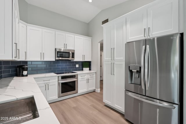 1057 W Laurel Ave, Gilbert, AZ 85233 - kitchen with appliances with stainless steel finishes, white cabinets, decorative backsplash, light wood-type flooring, and light stone countertops