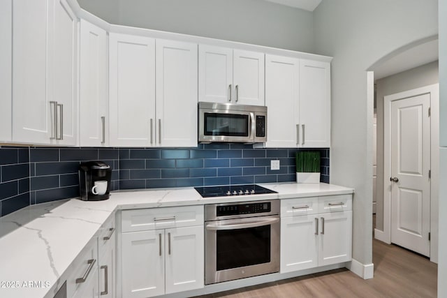 1057 W Laurel Ave, Gilbert, AZ 85233 - kitchen with stainless steel appliances, light wood finished floors, white cabinetry, and tasteful backsplash