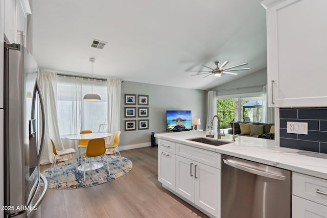 1057 W Laurel Ave, Gilbert, AZ 85233 - kitchen featuring stainless steel appliances, white cabinets, light wood-style flooring, a ceiling fan, and vaulted ceiling
