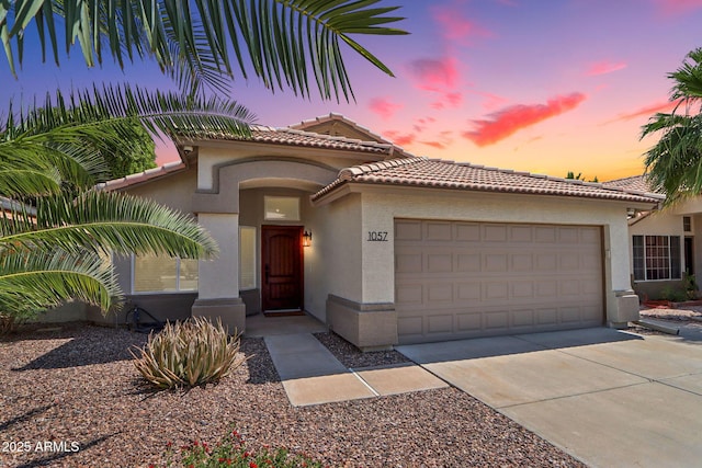1057 W Laurel Ave, Gilbert, AZ 85233 - mediterranean / spanish-style home with stucco siding, an attached garage, a tiled roof, and concrete driveway