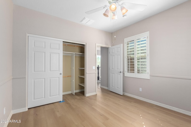 unfurnished bedroom with light hardwood / wood-style floors, ceiling fan, and a closet