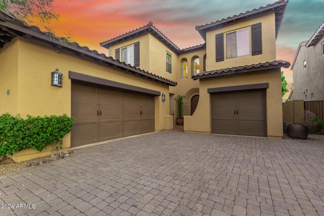 mediterranean / spanish home featuring a garage