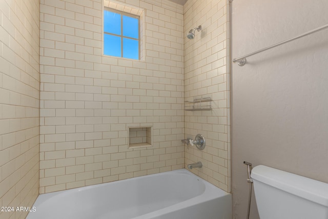 bathroom with tiled shower / bath and toilet