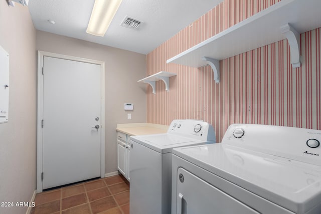 clothes washing area with separate washer and dryer, cabinets, and a textured ceiling