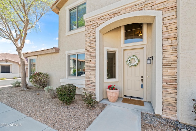 property entrance featuring stone siding and stucco siding