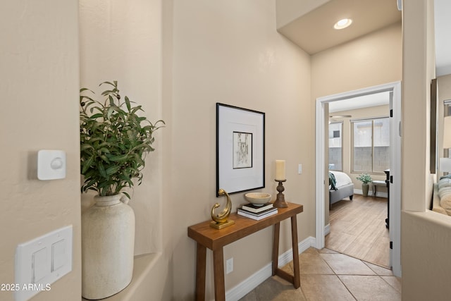 corridor with light tile patterned flooring, baseboards, and recessed lighting