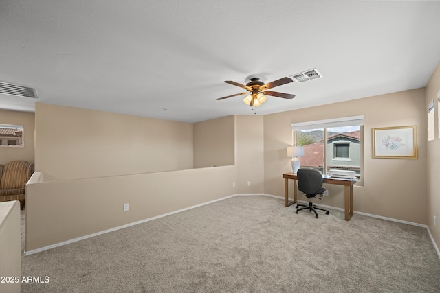 unfurnished office with carpet, baseboards, ceiling fan, and visible vents